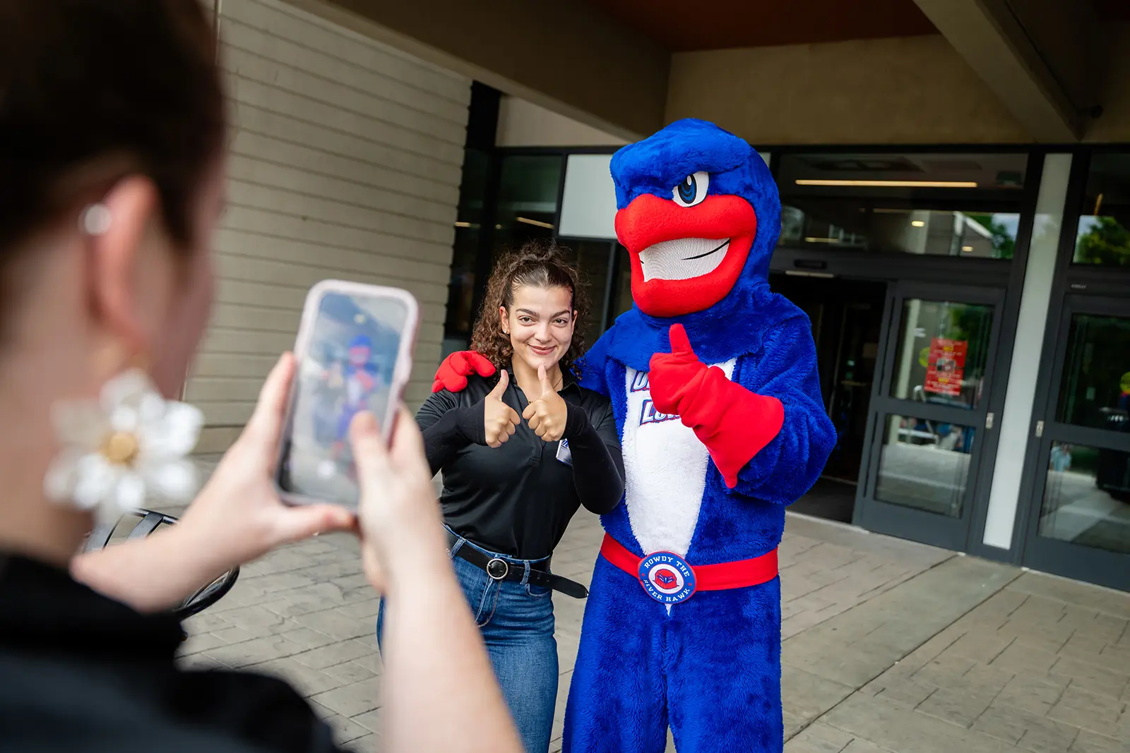 A student posing for a photo with Rowdy