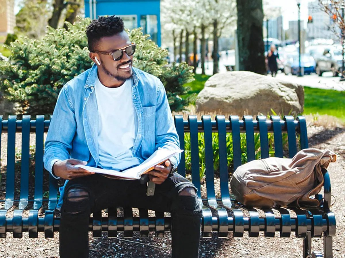 A student sitting on a bench with a book