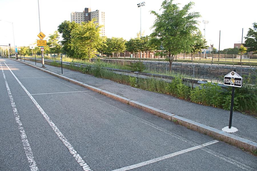 SUV parked in on-street parking spot along Fr. Morrissette Blvd. with Wannalancit Mills in background