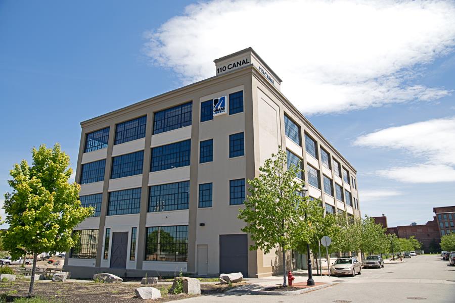 Square four-story gray building with large windows and 110 Canal on top