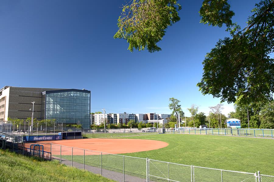 From along the first base line, view of dirt infield with South Parking Garage and Riverview Suites in background