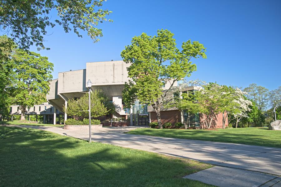 Brick and concrete music building behind trees