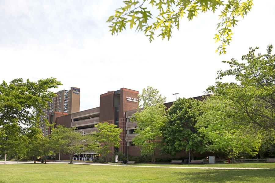 Six-story parking garage shot from entryway with trees in foreground