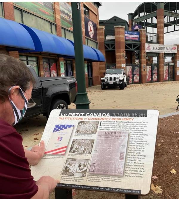 Person reads Little Canada info panel at LeLacheur Park