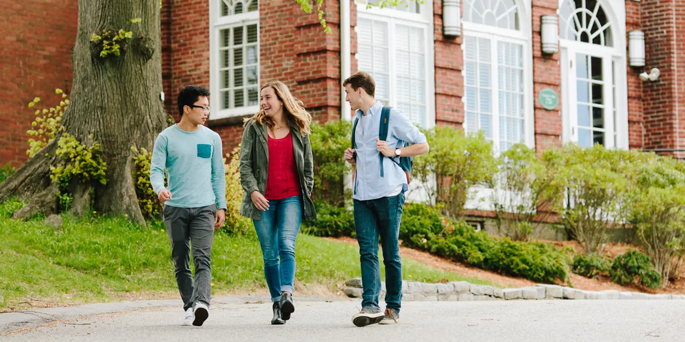 Two men and a woman walking in front of Allen House