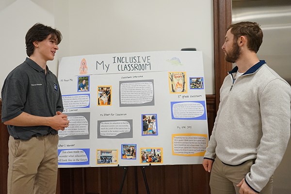 Lowell High School student Thomas Woodlock talks with UML education major Ryan Descheneaux about his poster