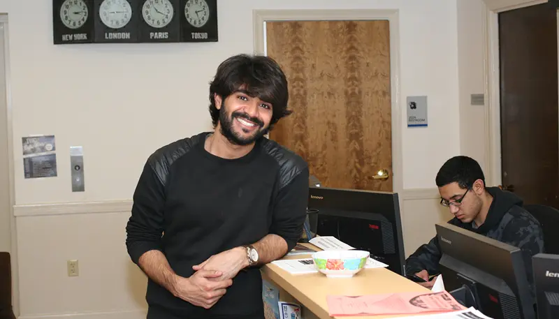 UMass Lowell graduate student Moiz Khan standing against desk