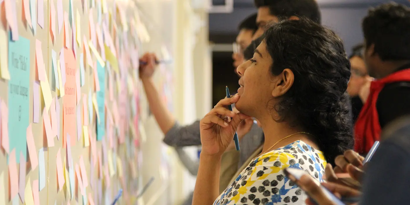 student writing a note to ISSO & GSSP at our End of Semester Celebration