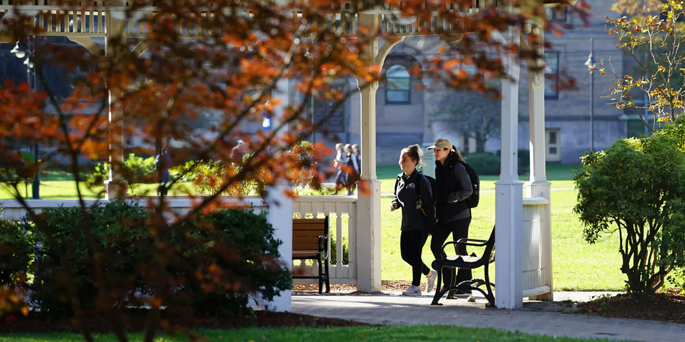 Two women walking under gazebo on south campus
